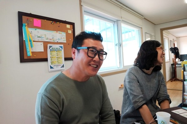 강동윤 사무국장과 류희진 팀장이 인터뷰 중 즐거이 웃고 있다.