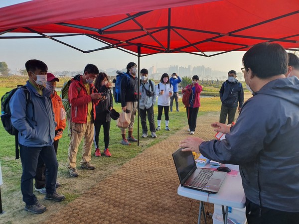 참가자들이 행사 부스에서 행사에 대한 설명을 듣고 있다.