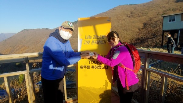 울산 영남알프스 행사의 도착지인 배내고개에서 오택준 대표에게 1,000km 기념 패치를 받는 박영미님