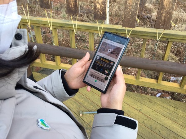 앱을 통해 숲길을 체험하며 걷는 모습