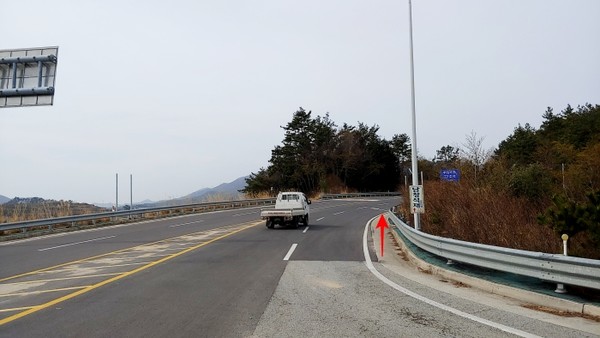 진행방향 (갓길의 폭이 넓고 코너를 돌아 나오는 차량이 보행자를 발견키 어렵다.)