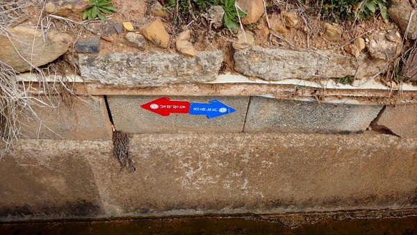 답사팀의 발 아래 수로의 벽에 붙어져 있다. 정방향으로는 보이지 않는다.