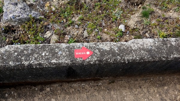 길 바깥쪽 수로의 경계석 바닥에 붙어져 있는 스티커. 일부러 찾지 않는 한 절대로 한 눈에 볼 수 없다. 